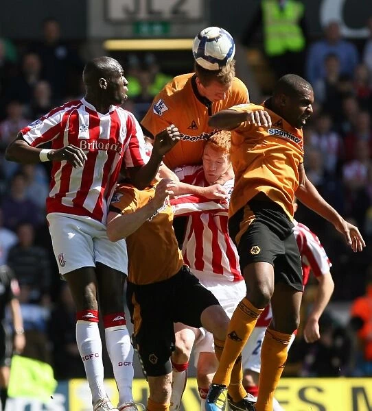 Intense Battle for the Ball: Wolverhampton Wanderers vs Stoke City - Christophe Berra's Headed Clash in Barclays Premier League