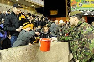 Wolves v Arsenal Collection: Wolverhampton Wanderers: Soldier Collects Donations in Billy Wright Stand During Wolves vs